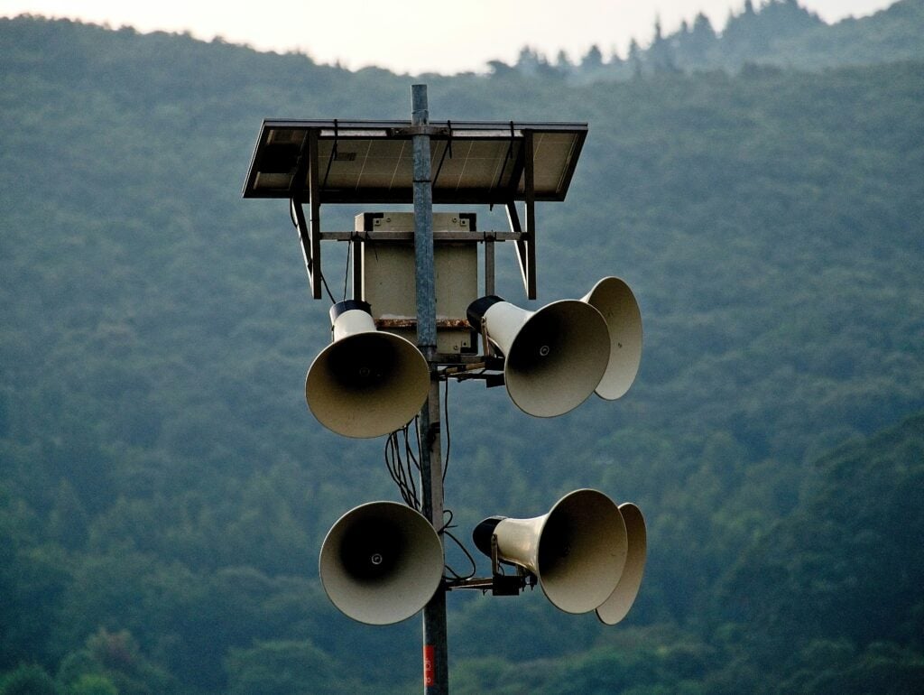 A pole with lots of speakers on it